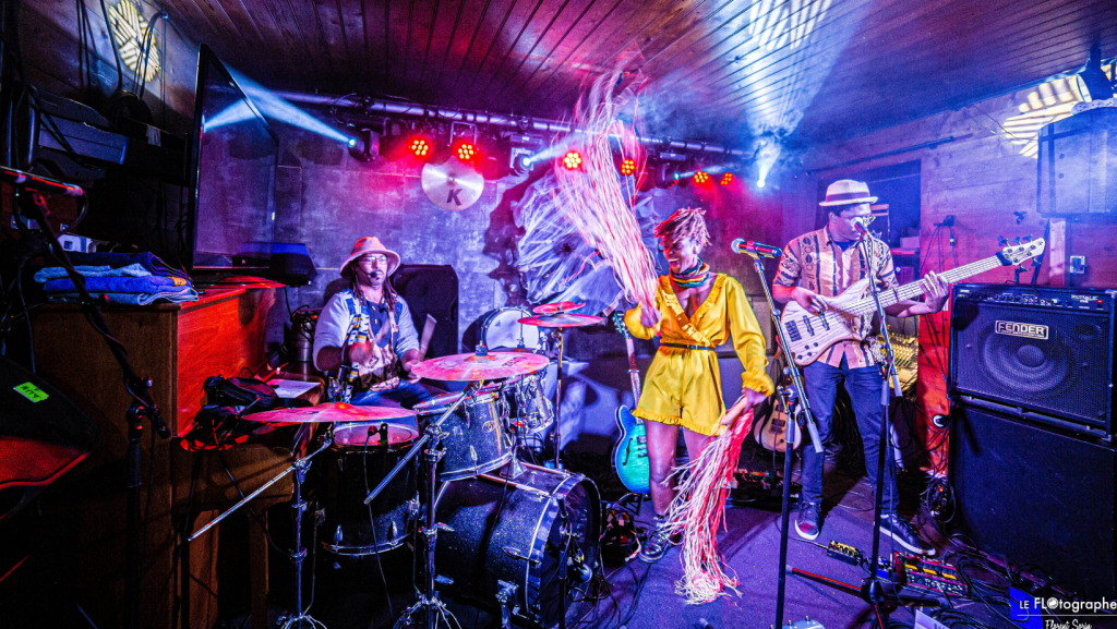 Pamela Badjogo sur scène accompagnée de 2 de ses musiciens sur la scène d'un bar à L'Ile d'Yeu pendant le festival Les Berniques en Folie