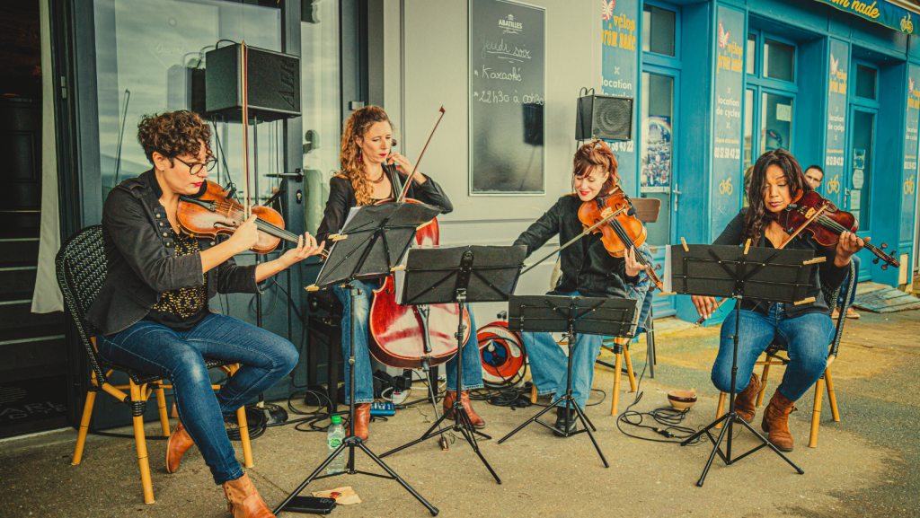 Quatuor de 3 violonistes et une contre basse jouant devant un bar à L'Ile d'Yeu pendant le festival Les Berniques en Folie
