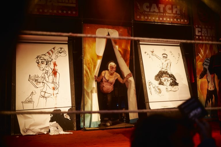 Sur un ring, deux artistes s’affrontent en un match de deux rounds via deux grands dessins dont les thèmes ont été proposés par le public.